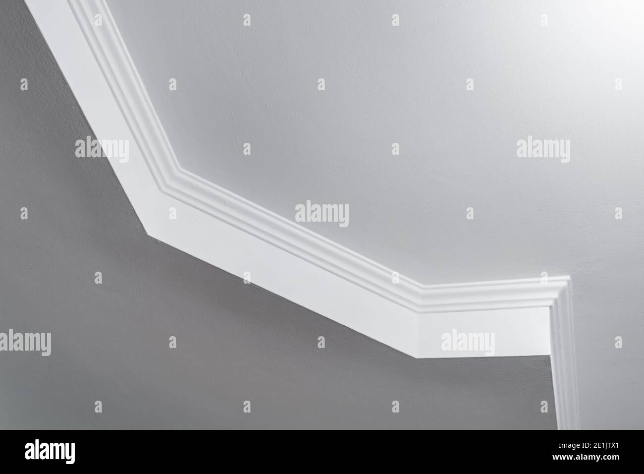 Detail der Eckdecke mit aufwändigen Stuckverzierungen. Abgehängte Decke und Trockenbau in leerem Raum in Wohnung oder Haus. Dehnbare Decke Stockfoto