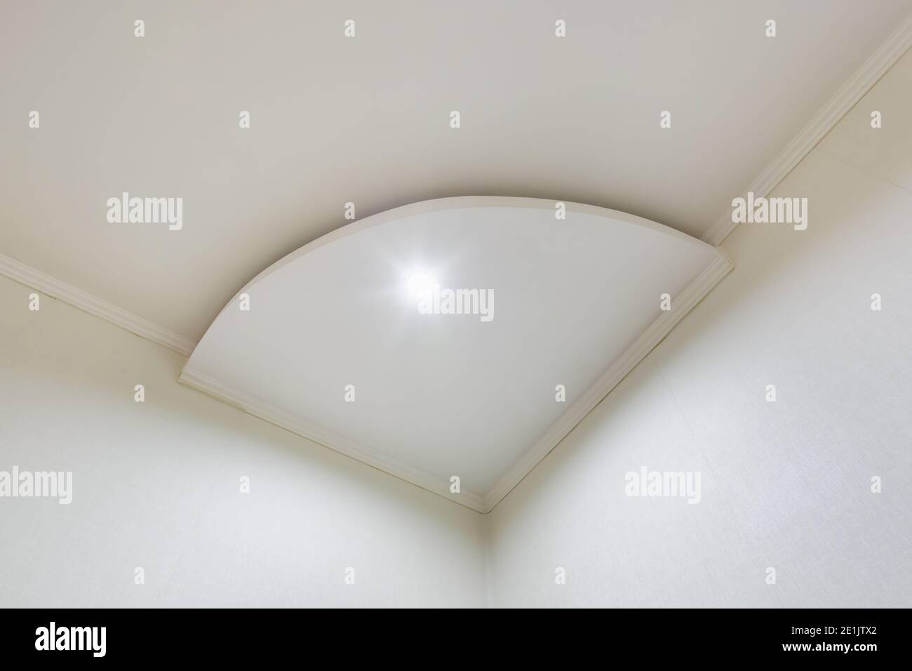 Detail der Eckdecke mit aufwändigen Stuckverzierungen. Abgehängte Decke und Trockenbau in leerem Raum in Wohnung oder Haus. Dehnbare Decke Stockfoto