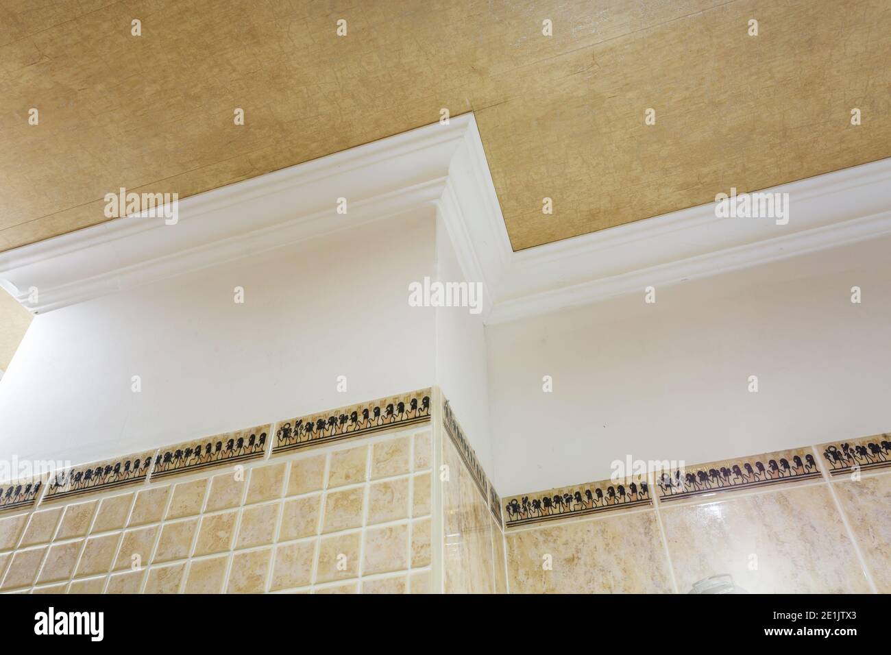 Detail der Eckdecke mit aufwändigen Stuckverzierungen. Abgehängte Decke und Trockenbau in leerem Raum in Wohnung oder Haus. Dehnbare Decke Stockfoto
