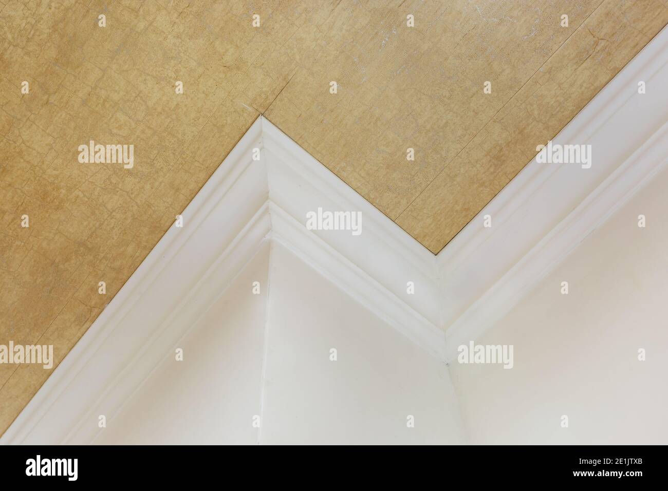 Detail der Eckdecke mit aufwändigen Stuckverzierungen. Abgehängte Decke und Trockenbau in leerem Raum in Wohnung oder Haus. Dehnbare Decke Stockfoto