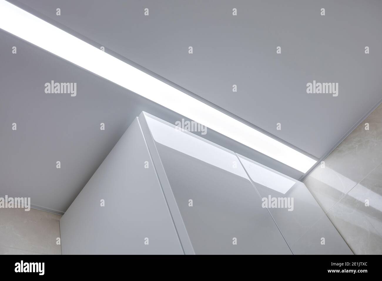 Abgehängte Decke mit Halogenstrahlern und Trockenmauerkonstruktion im leeren Raum in Wohnung oder Haus. Stretchdecke weiß und komplex. Stockfoto