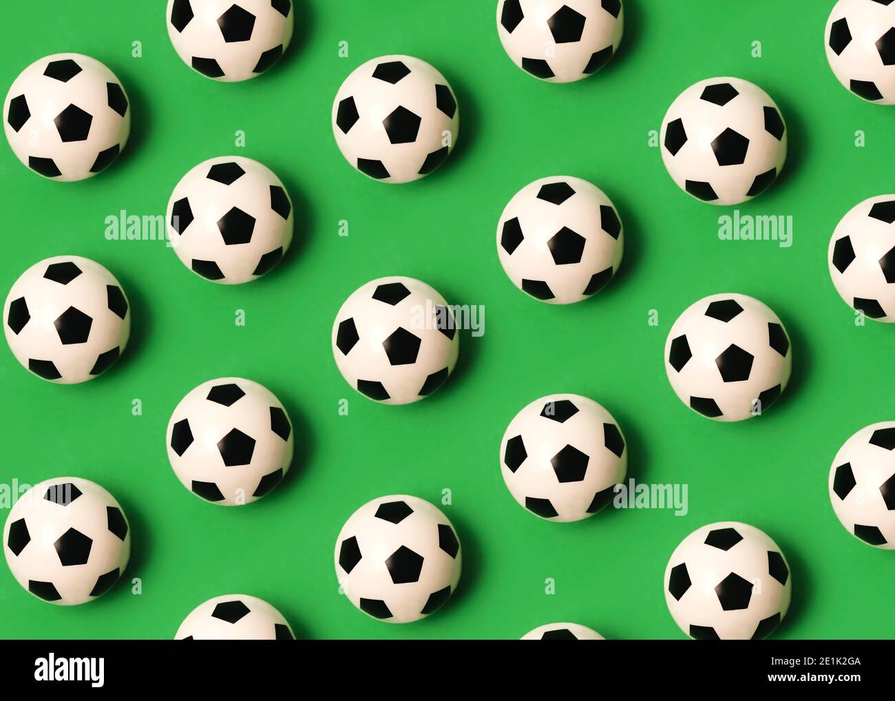 Geometrisches Muster mit Fußballbällen auf grünem Hintergrund Stockfoto