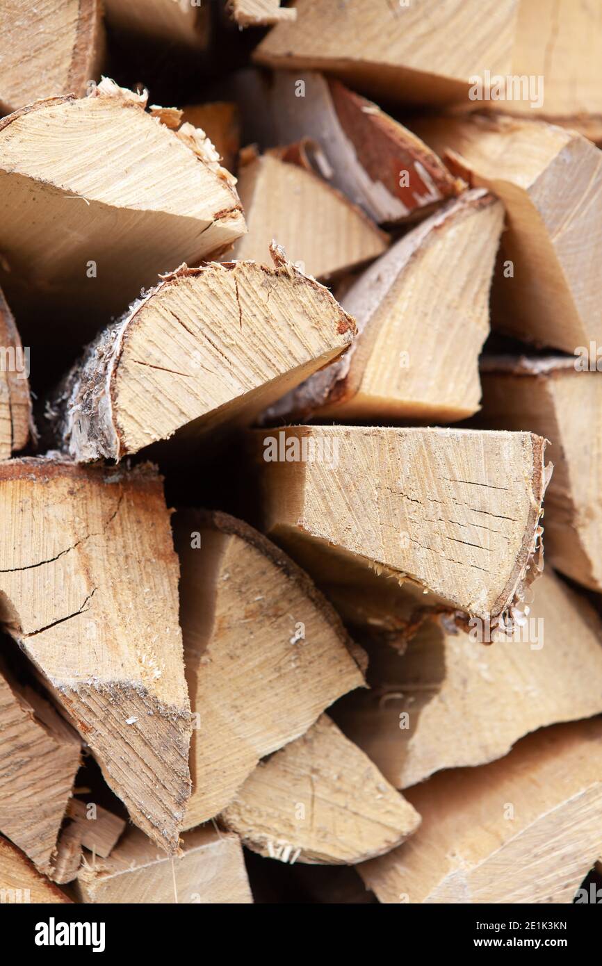 Hintergrund aus Holzstapel aus Birke, für die Heizung Haus, im Hinterhof gestapelt, ungeschnittenes Holz, Birke. Konzept umweltfreundliche Heizung während Stockfoto