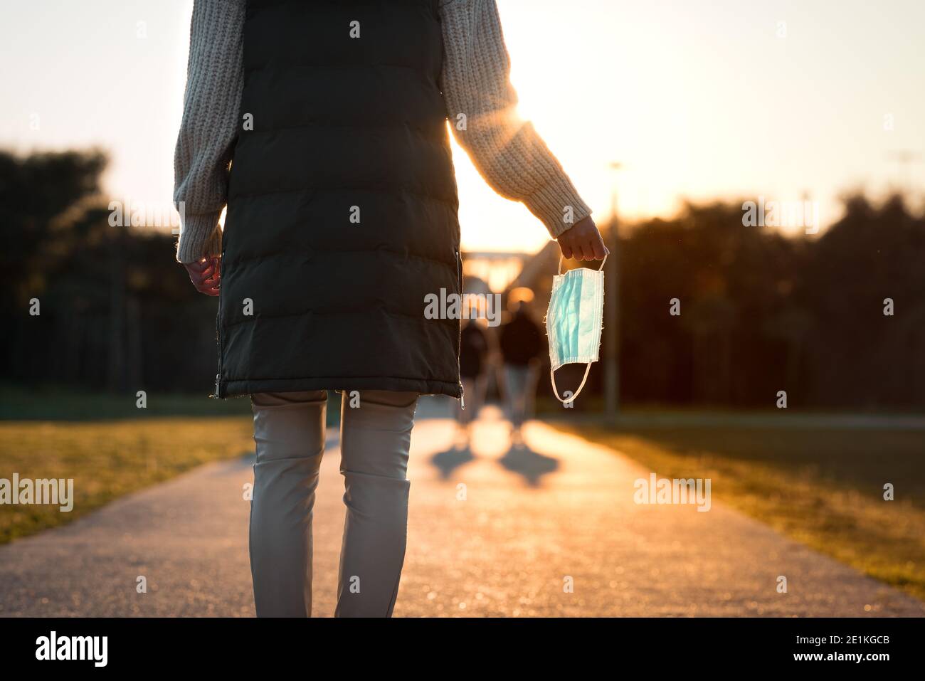 Frau nimmt die Maske. Das Ende der Coronavirus-Pandemie. Von Coronavirus geborgen. Krankheit besiegen. Coronavirus-Quarantäne ist vorbei. Wir haben gewonnen Stockfoto