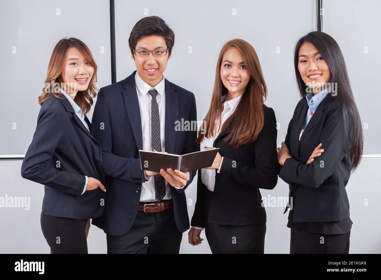 Junge Geschäftsleute konzentrieren sich auf Buchstand und Lächeln Mit weißem Hintergrund Stockfoto