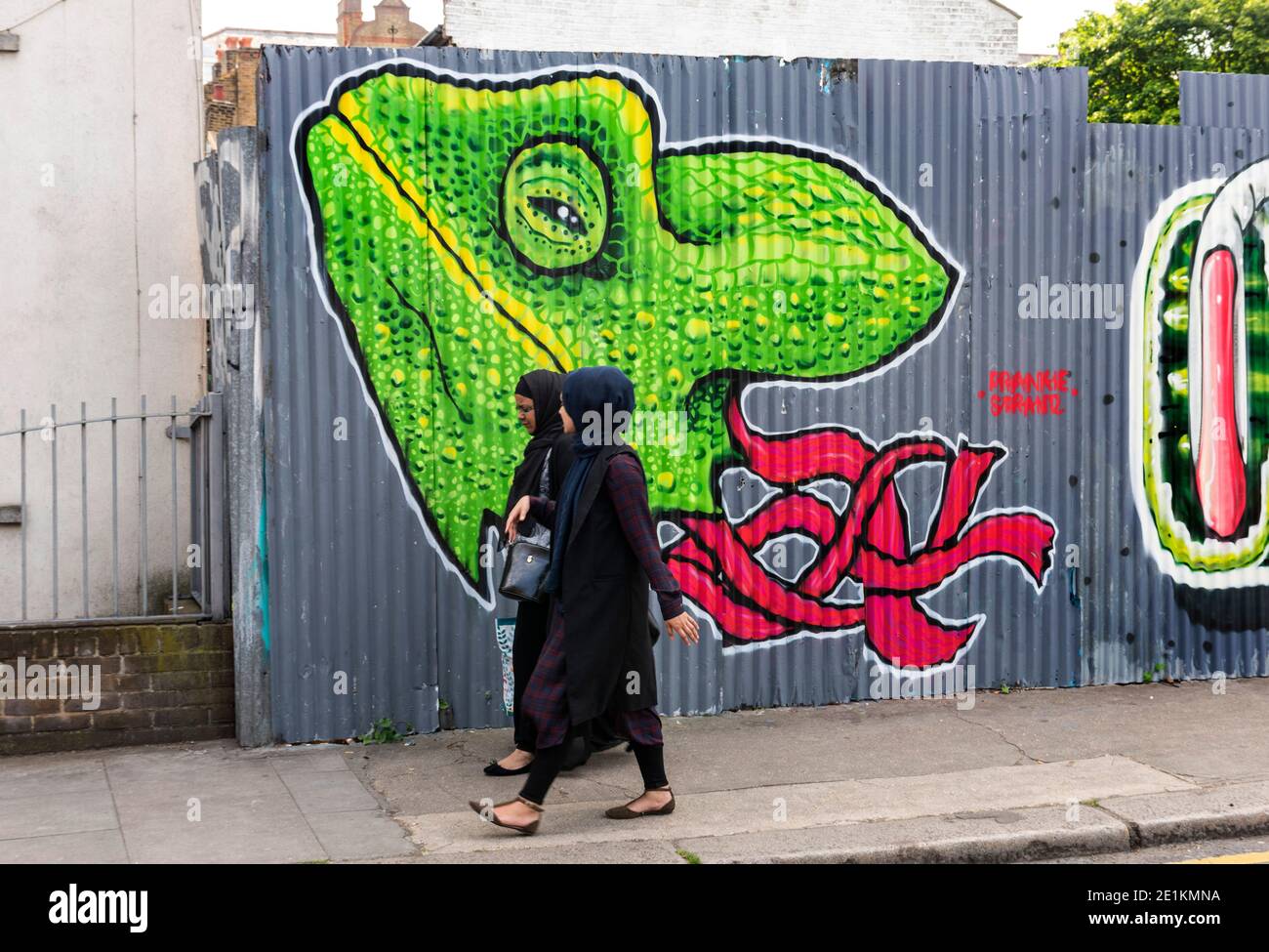 London, England: 24. Mai 2017. 2 muslimische Damen gehen an einem Street Art-Werk von Frankie Strand in der Nähe der Brick Lane, Shoreditch, London, Großbritannien vorbei. Alamy Stockbild/ Stockfoto