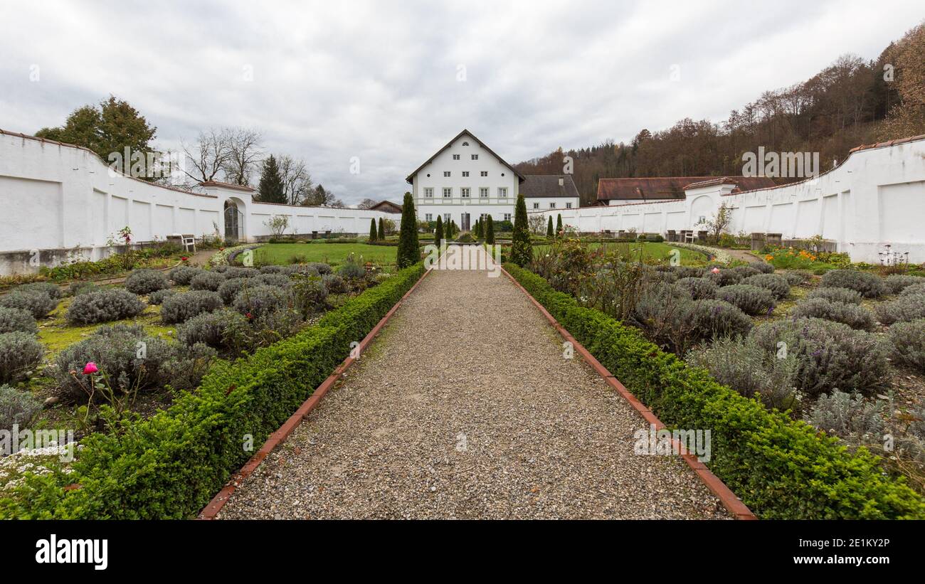 Schäftlarn, Deutschland - 17. Nov 2020: Blick auf einen Pfad in den Garten des Klosters Schäftlarn. Umgeben von weißen Wänden, in der Ferne ein Gebäude Stockfoto
