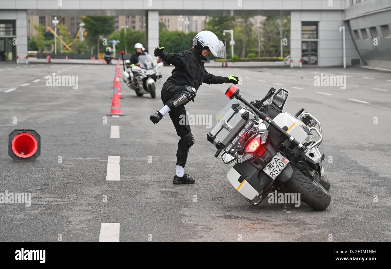 (210108) -- FUZHOU, 8. Januar 2021 (Xinhua) -- Cai Jingye, ein Mitglied eines Motorradteams für Verkehrspolizisten, springt während eines Fahrtrainings in der Stadt Fuzhou, südöstlich der Provinz Fujian in China, vom 16. Dezember 2020 von einem fallenden Motorrad herunter. Das erste Verkehrspolizisten-Motorradteam der Stadt wurde Tage vor dem bevorstehenden ersten chinesischen Polizeitag, der am 10. Januar 2021 angesetzt wird, gegründet. Mit einer durchschnittlichen Höhe von bis zu 1.7 Metern sind diese Motorradfahrerinnen in schönen Uniformen gut ausgebildet, um das etwa 300 kg schwere Polizeimotorrad fahren zu können, um Dienst zu leisten, ohne dabei die Aufmerksamkeit zu erregen Stockfoto