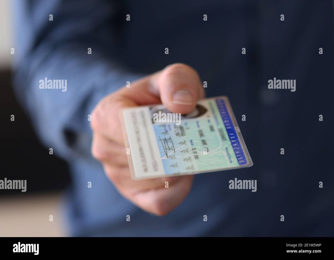 Ein junger Mann reicht seinen französischen Personalausweis - Französischer Personalausweis Stockfoto