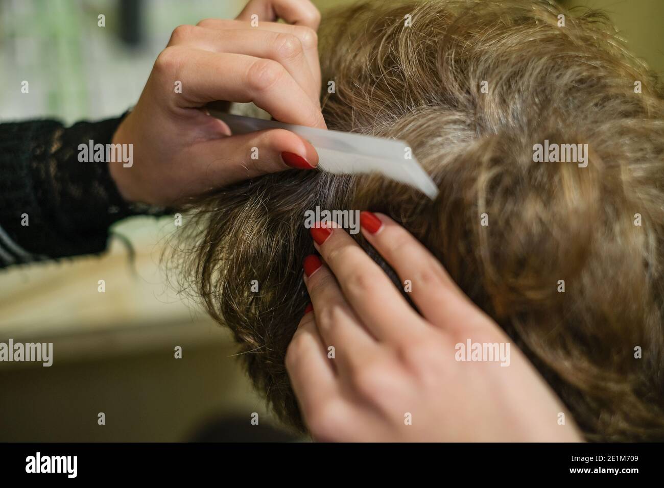 Friseur Mädchen beim Auftragen von Haarfarbe auf eine weiße Behaarte ältere Frau Kunde bei der Arbeit, zu Hause Schönheitsbehandlung Stockfoto