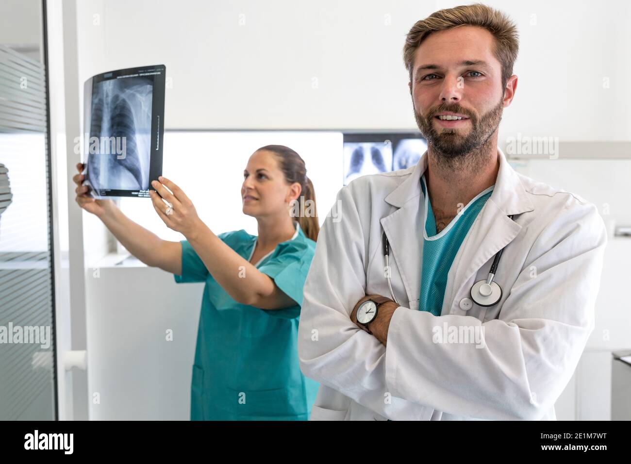 Porträt eines jungen lächelnden Arzt isoliert auf verschwommen medizinischen Hintergrund mit Kopierbereich Stockfoto