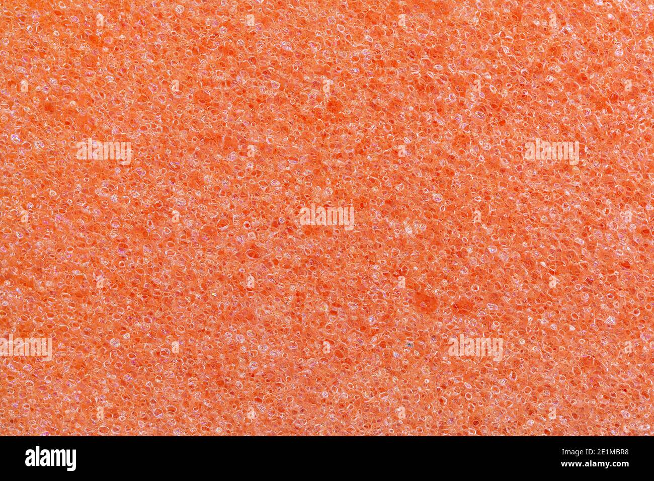 Orange Schaumstoff Küche Schwamm Textur. Vollformat-Makrofotografie von porösem Kunststoff. Abstraktes Muster Hintergrund für Reinigung und Hausarbeit. Stockfoto