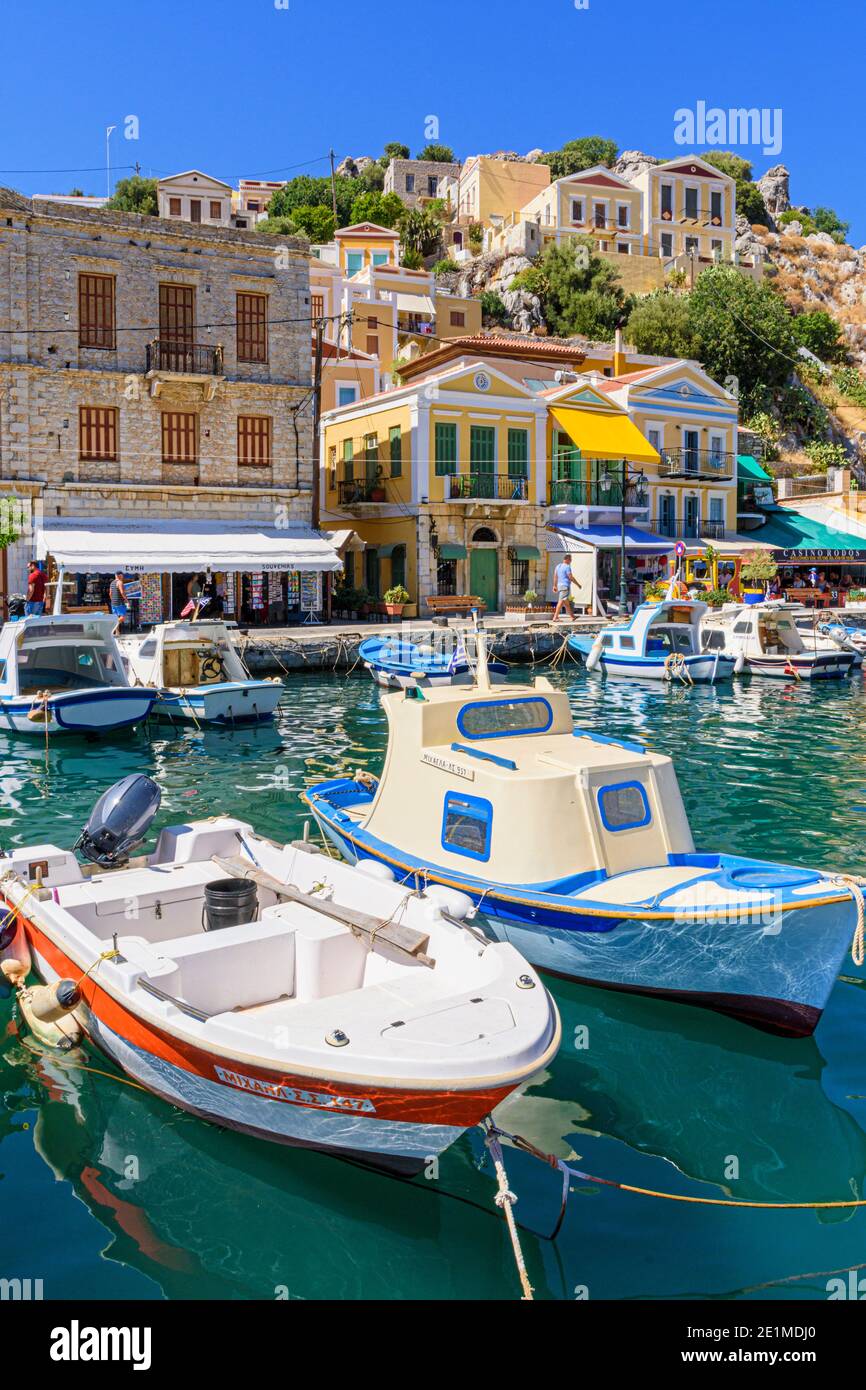 Kleine Fischerboote entlang der Uferpromenade von Symi Town, Gialos, Symi Island, Griechenland Stockfoto