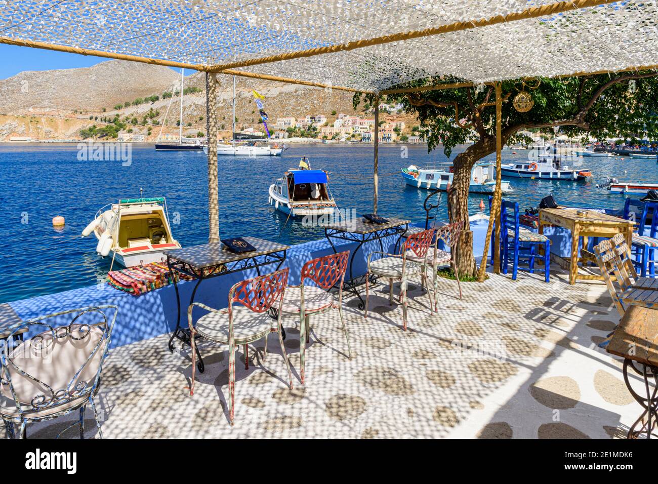 Blick auf die Gialos Bucht von einer Taverne am Wasser auf der griechischen Insel Symi, Dodekanes, Griechenland Stockfoto