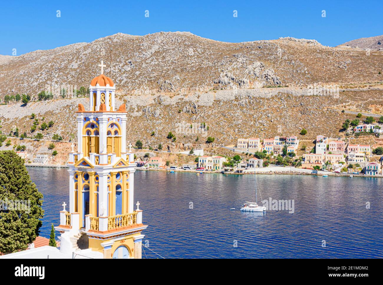 Der Glockenturm der Verkündigung-Kirche mit Blick auf die Südseite des Hafens von Gialos, Symi Island, Dodekanes, Griechenland Stockfoto