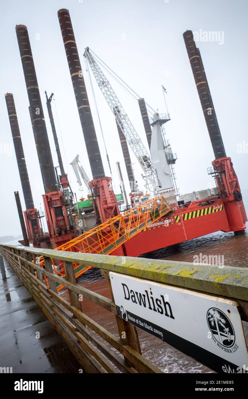 Wave Walker Jack-up Barge hilft beim Bau einer neuen größeren Meeresmauer in Dawlish zum Schutz der Eisenbahn, Devon, England. Stockfoto