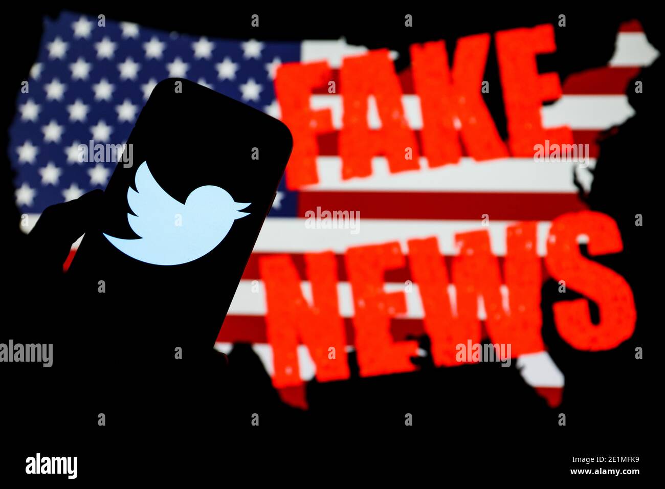 In diesem Foto Illustration Twitter Social Media App Firmenlogo auf einem Smartphone angezeigt. Amerikanische Flagge mit Aufschrift 'Fake News' ist sichtbar Stockfoto