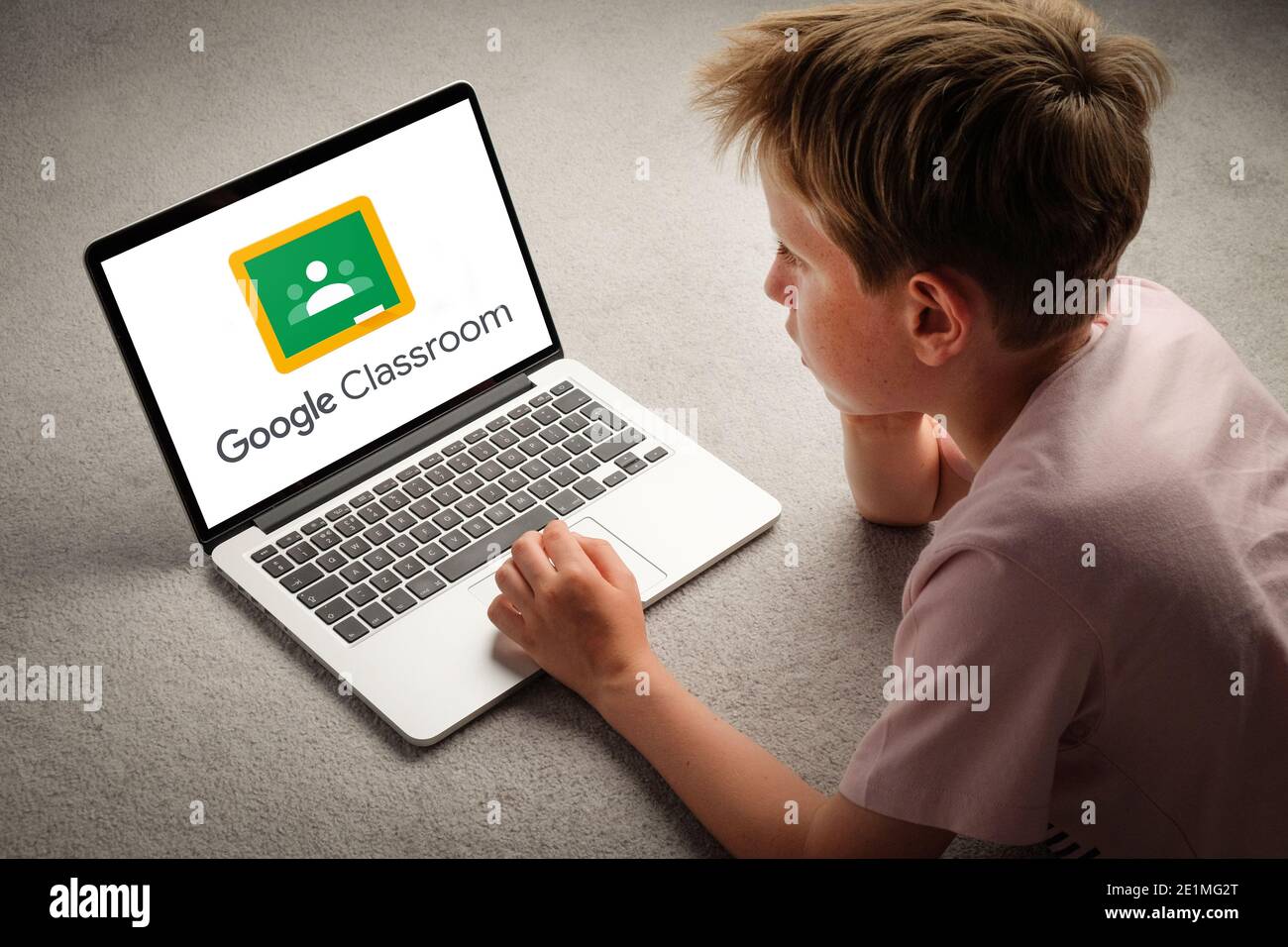 Ein Kind, das über die Google Classroom-Website lernt, während es während der Sperrung von zu Hause aus lernt. Stockfoto