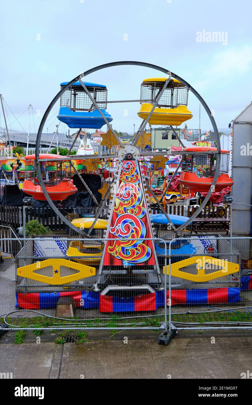 Bunte kleine Riesenrad im geschlossenen Messegelände in Pensarn, Nordwales. Stockfoto