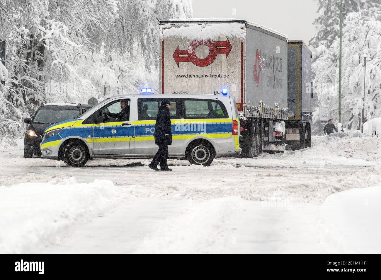 Roetgen, Deutschland. Januar 2021. Polizeibeamte regeln den Verkehr auf der Bundesstraße 258 bei Roetgen. Schnee und vereiste Straßen haben in Teilen Nordrhein-Westfalens zu Störungen geführt. Quelle: Federico Gambarini/dpa/Alamy Live News Stockfoto