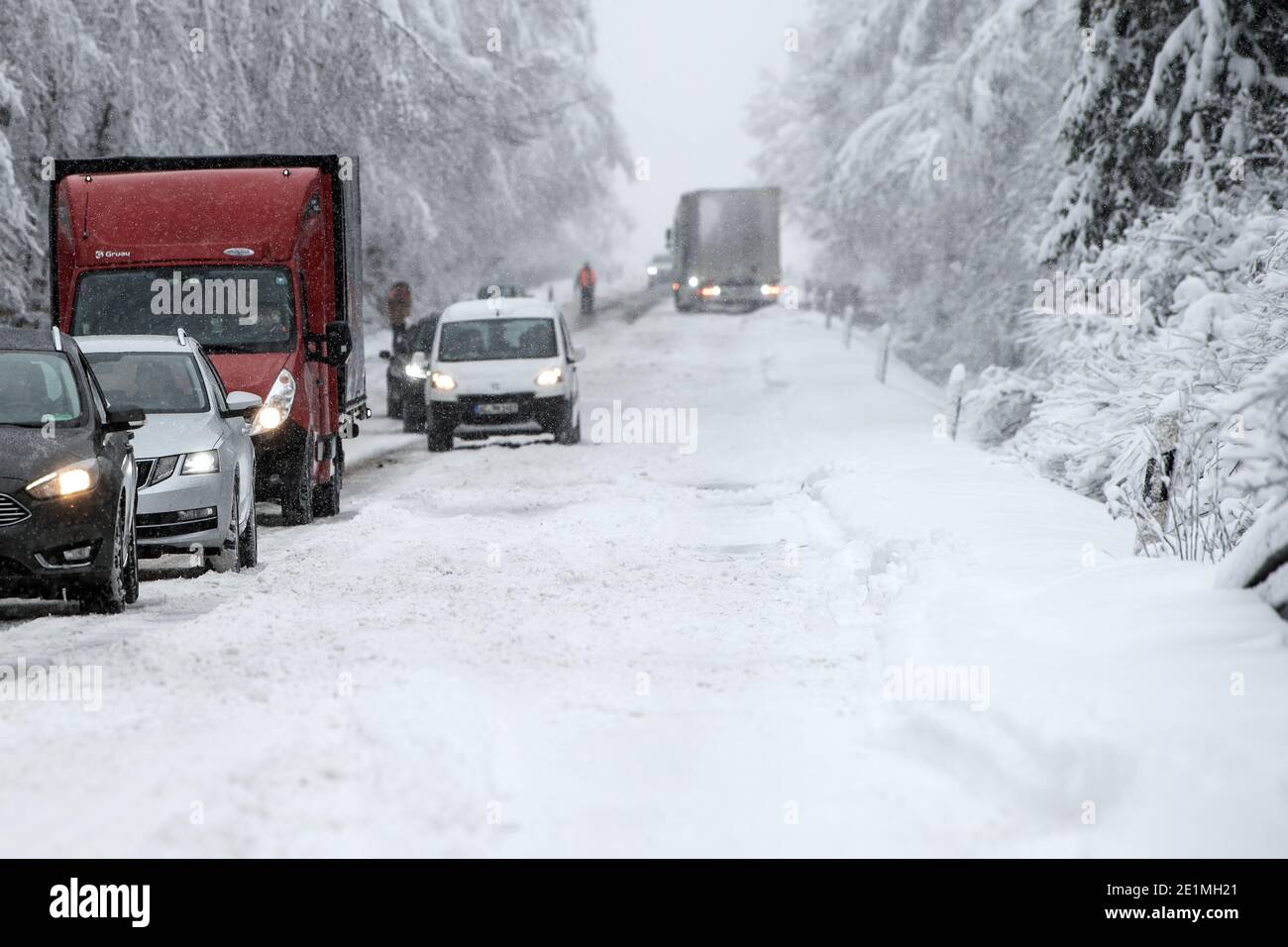 Roetgen, Deutschland. Januar 2021. Autos und Lastwagen stecken auf der B258 bei Roetgen im Verkehr fest. Schnee und vereiste Straßen haben in Teilen Nordrhein-Westfalens zu Störungen geführt. Quelle: Federico Gambarini/dpa/Alamy Live News Stockfoto