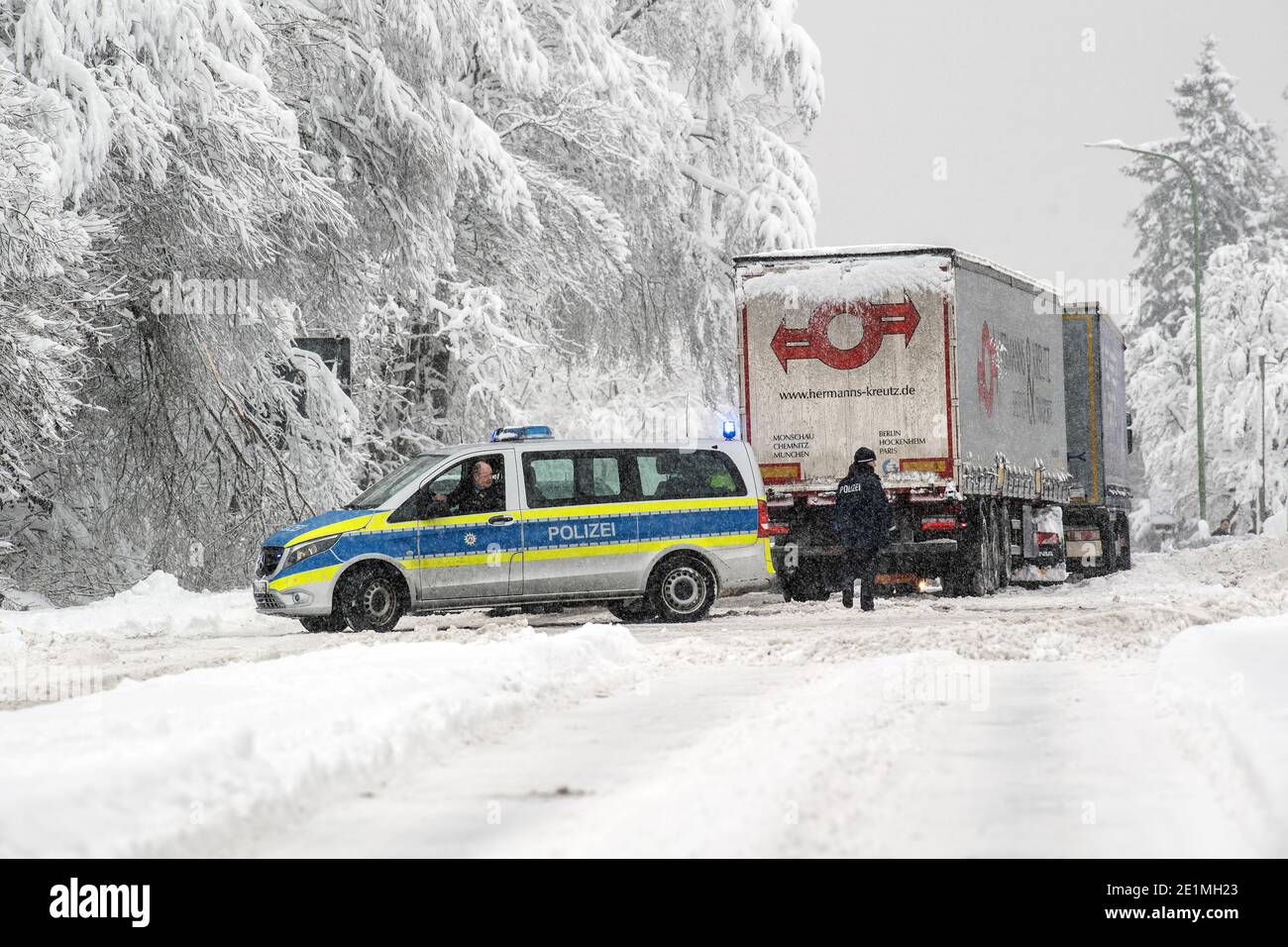 Roetgen, Deutschland. Januar 2021. Polizeibeamte regeln den Verkehr auf der Bundesstraße 258 bei Roetgen. Schnee und vereiste Straßen haben in Teilen Nordrhein-Westfalens zu Störungen geführt. Quelle: Federico Gambarini/dpa/Alamy Live News Stockfoto