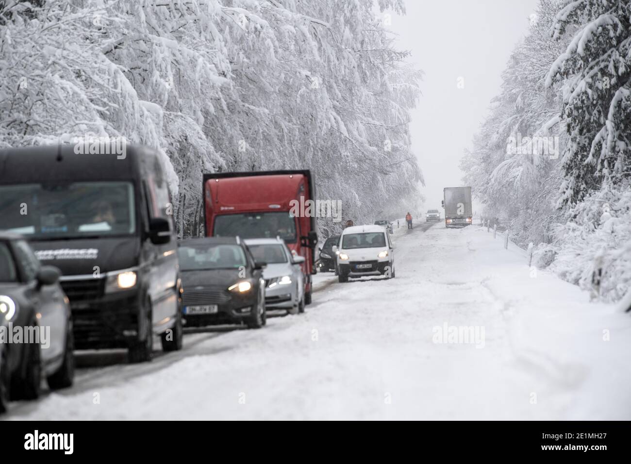 Roetgen, Deutschland. Januar 2021. Autos und Lastwagen stecken auf der B258 bei Roetgen im Verkehr fest. Schnee und vereiste Straßen haben in Teilen Nordrhein-Westfalens zu Störungen geführt. Quelle: Federico Gambarini/dpa/Alamy Live News Stockfoto
