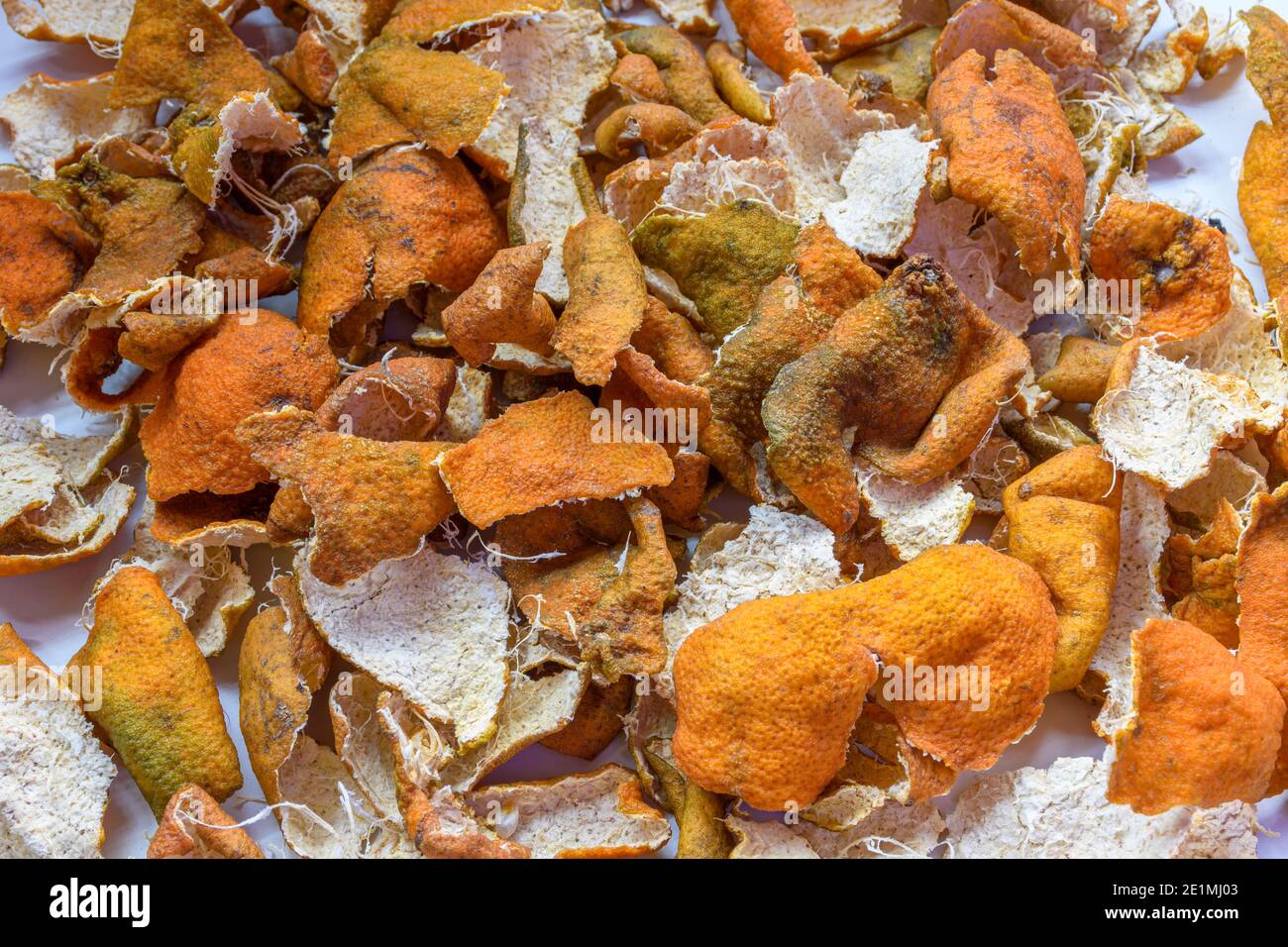 Bild von hausgemachter kandierter Orangenschale unter der Sonne für getrockneten Prozess auf einer weißen Oberfläche. Stockfoto