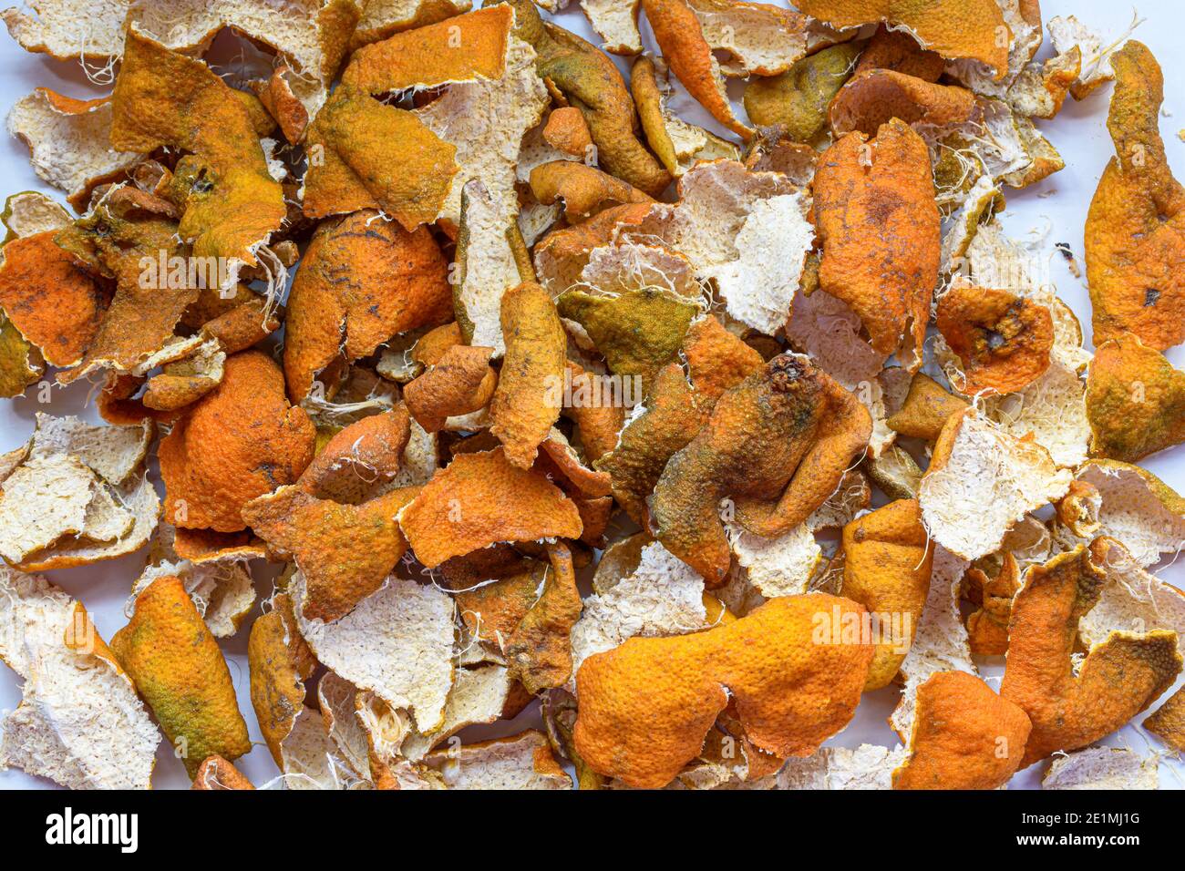 Bild von hausgemachter kandierter Orangenschale unter der Sonne für getrockneten Prozess auf einer weißen Oberfläche. Stockfoto