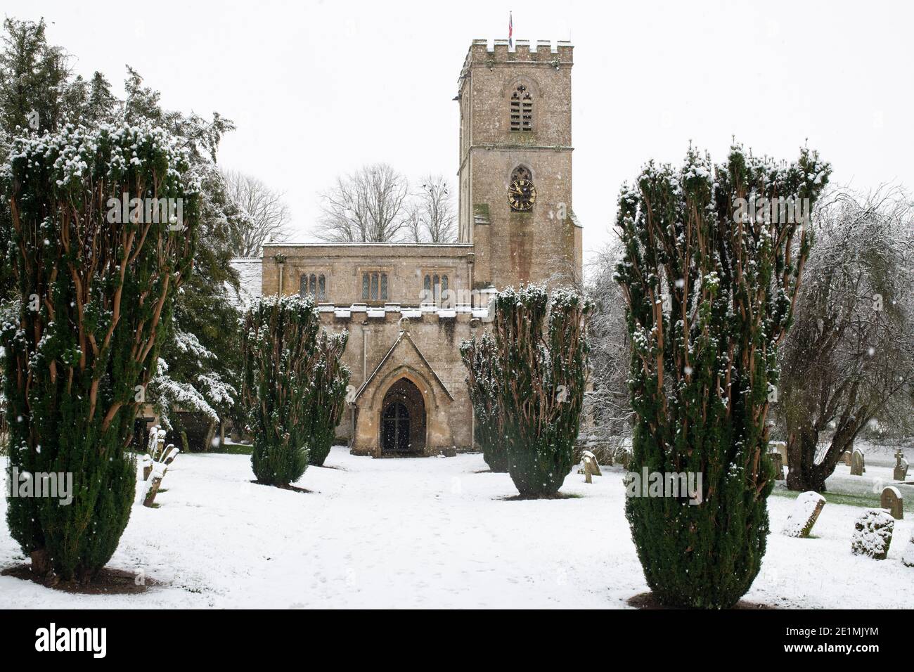 St. Johannes der Evangelist Pfarrkirche im Dezember Schnee. Taynton, Cotswolds, Oxfordshire, England Stockfoto