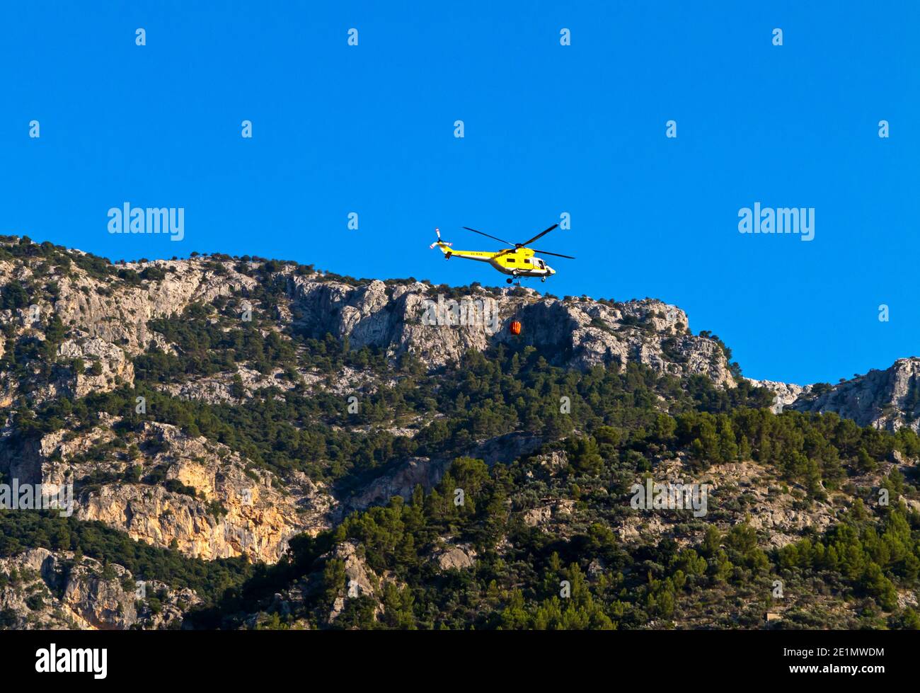 Hubschrauber mit Wasser, um einen Waldbrand zu löschen Die Serra de Tramuntana Bergkette im Nordwesten Mallorcas Balearen Spanien Stockfoto