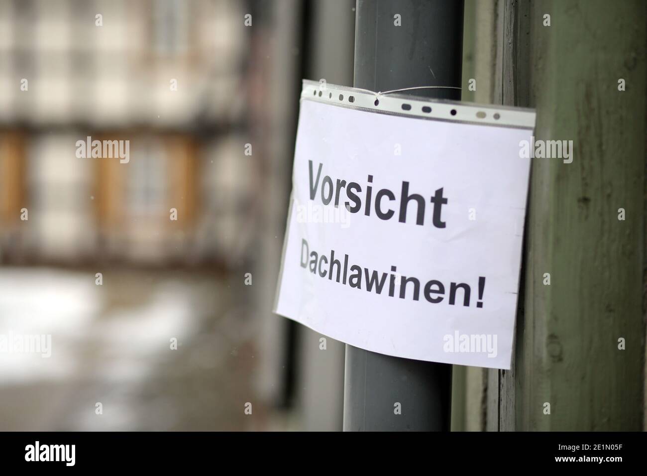 Wernigerode, Deutschland. Januar 2021. Schnee liegt auf den Dächern von Häusern. Mit dem Einsetzen des Tauwetters besteht die Gefahr fallender Schneemassen, auch Dachlawinen genannt. Hausbesitzer verwenden Schilder, um die vorbeifahrenden Menschen auf die Gefahr aufmerksam zu machen. Quelle: Matthias Bein/dpa-Zentralbild/ZB/dpa/Alamy Live News Stockfoto