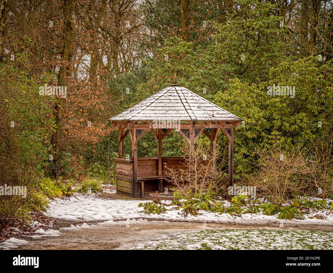 Verschneite hexagonale Holzpavillon im Wald von Harlow Carr. North Yorkshire, Großbritannien Stockfoto