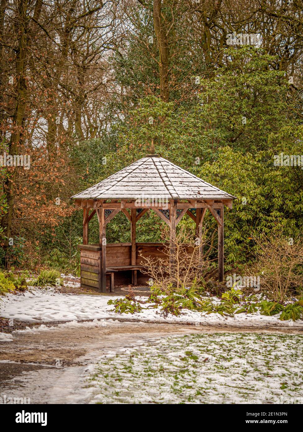 Verschneite hexagonale Holzpavillon im Wald von Harlow Carr. North Yorkshire, Großbritannien Stockfoto