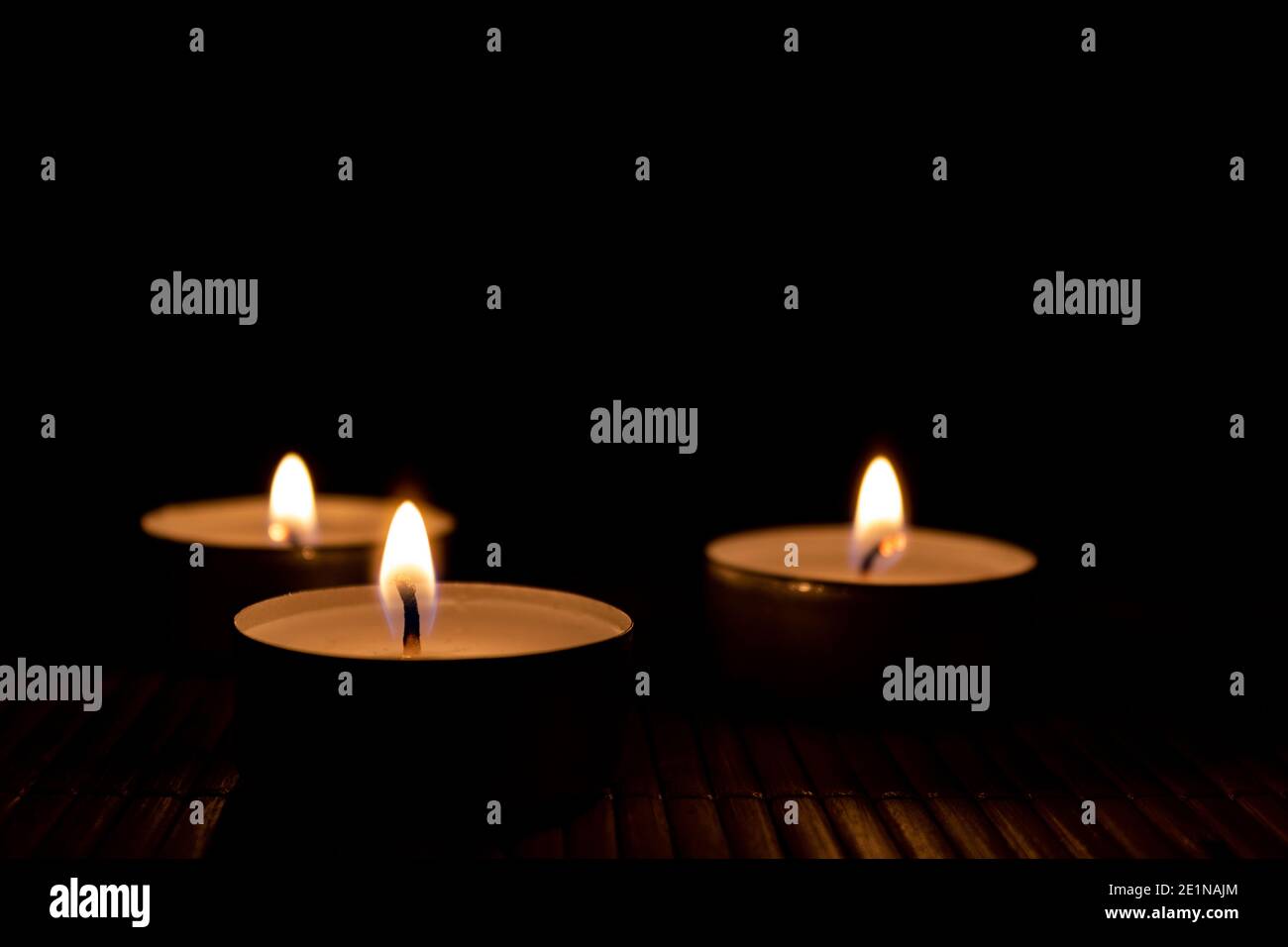 Drei brennende Kerzen, Nahaufnahme und selektiver Fokus auf den Vordergrund. Kerzen im Dunkeln mit Platz für Text Stockfoto