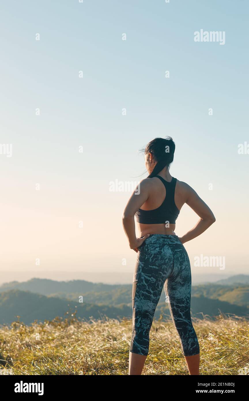 Ein Porträt der stolzen Frau in sportlicher Kleidung mit ihr Hände auf Hüften stehen nach dem Training Stockfoto