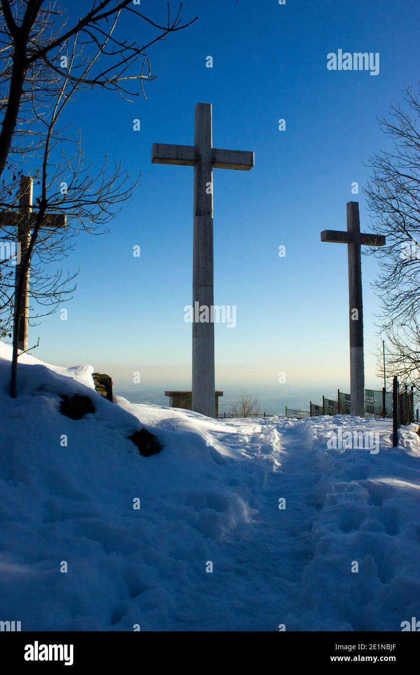 Drei gigantische Kreuze auf der Spitze eines Berges, eingetaucht in den Januarschnee, im Hintergrund ein intensiver blauer Himmel Stockfoto