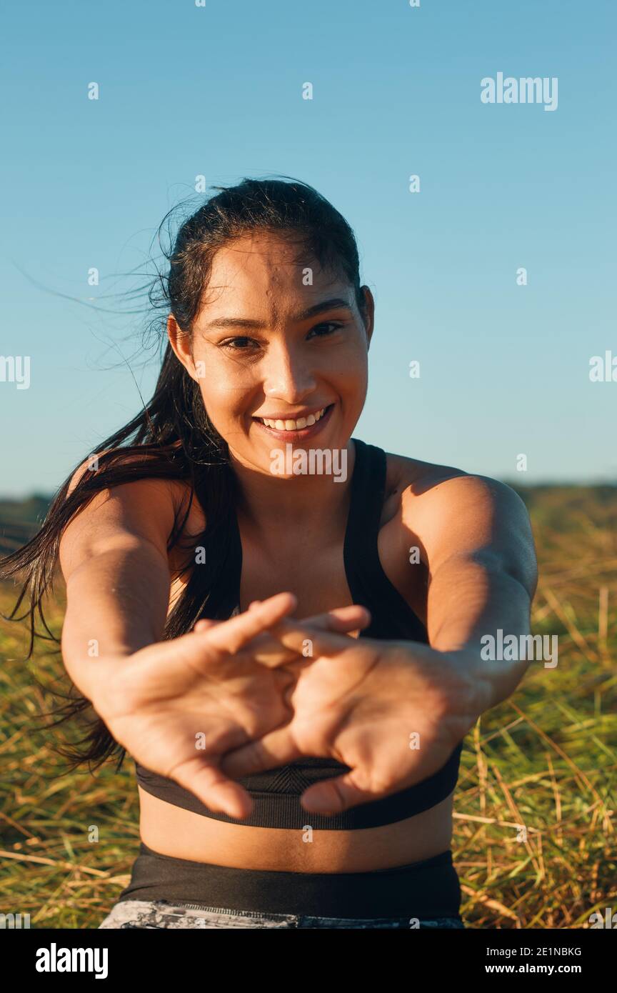 Ein flacher Fokus von einer glücklichen Frau, die sie streckt Körper im Freien Stockfoto