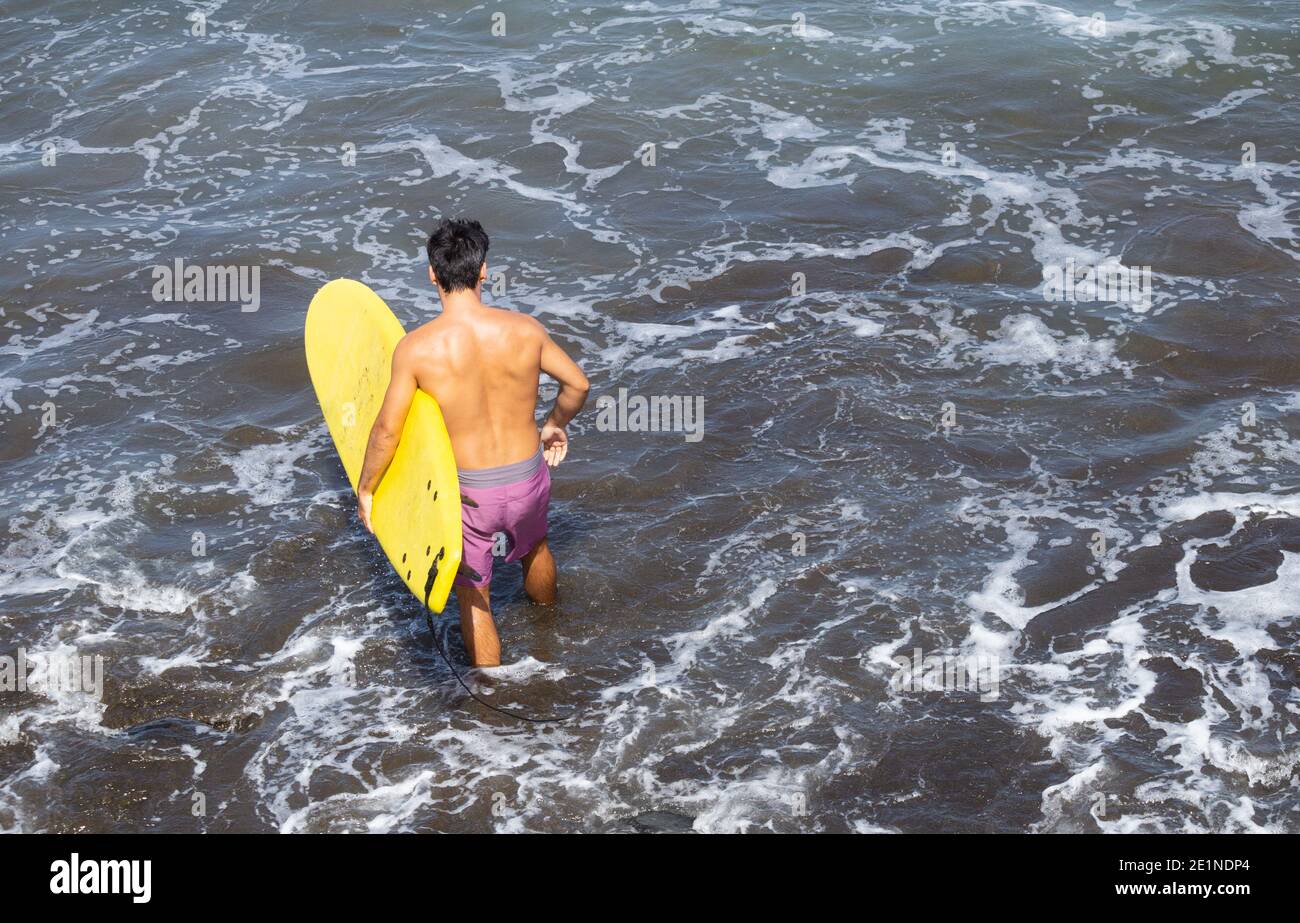 Surfer mit gelbem Surfbrett. Stockfoto