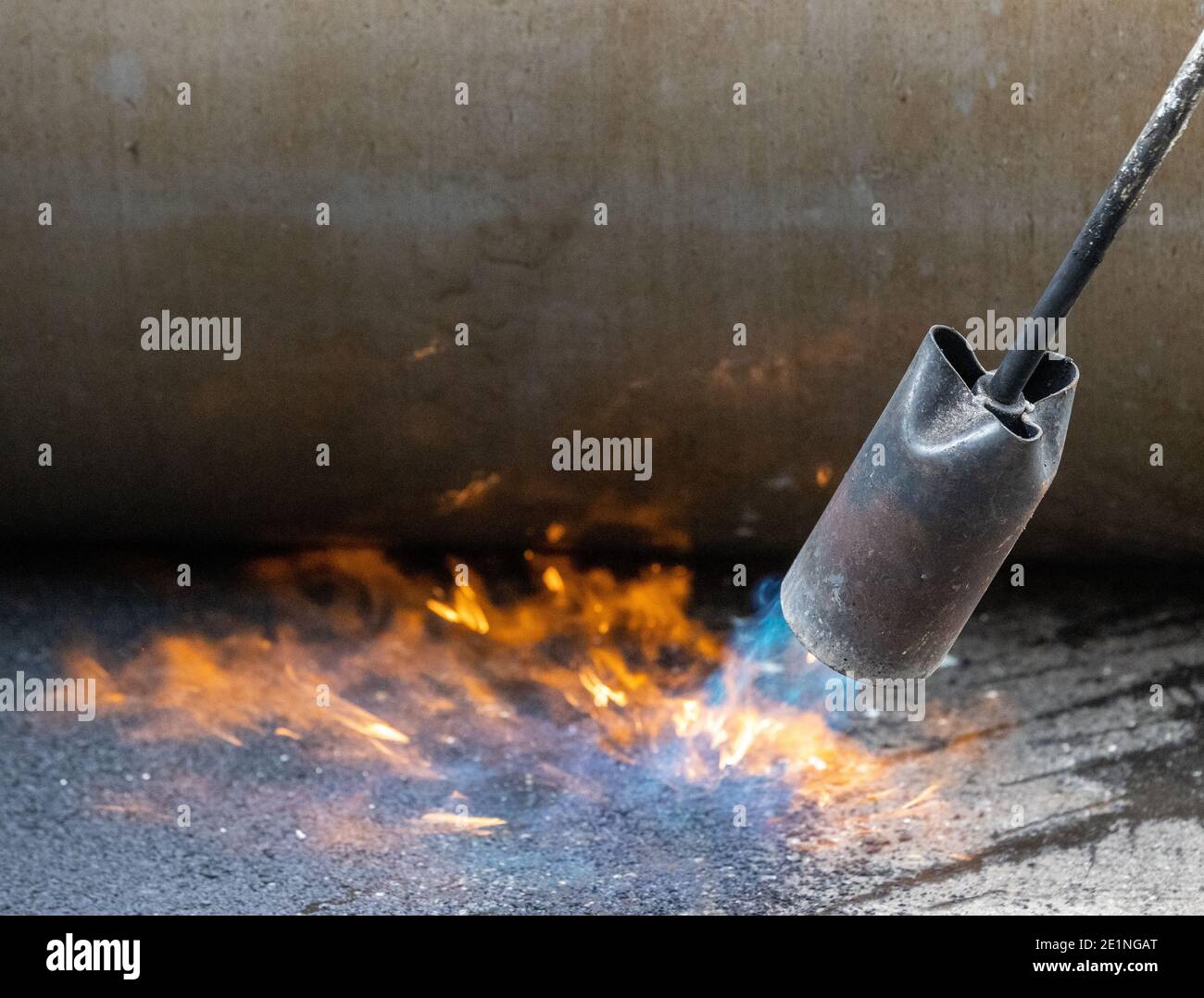 Flamme und Dampf steigt als Asphaltnaht ist versiegelt und Gerollt Glatt Stockfoto