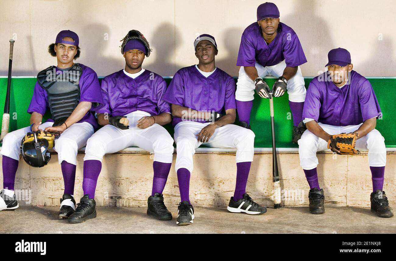 Porträt afroamerikanischer Baseballspieler, die nebeneinander sitzen Im Dugout Stockfoto