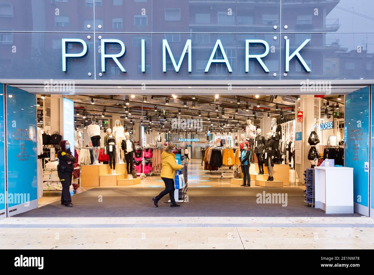 Menschen mit Gesichtsmasken gehen während der Winterverkäufe an einem Primark-Laden vorbei.in den letzten Weihnachtswochen haben die Fälle von Covid19 in Valencia zugenommen, was dazu geführt hat, dass die Winterverkäufe beginnen, begleitet von neuen Anti-Covid-Maßnahmen, die auch die Gaststättebranche betreffen. Bis zum 31. Januar schließen die Bars und Restaurants um 17:00 Uhr und maximal vier Personen pro Tisch. Die Kapazität wird in Geschäften und Nachtmobilität bis 10 Uhr auf 30% reduziert. Stockfoto