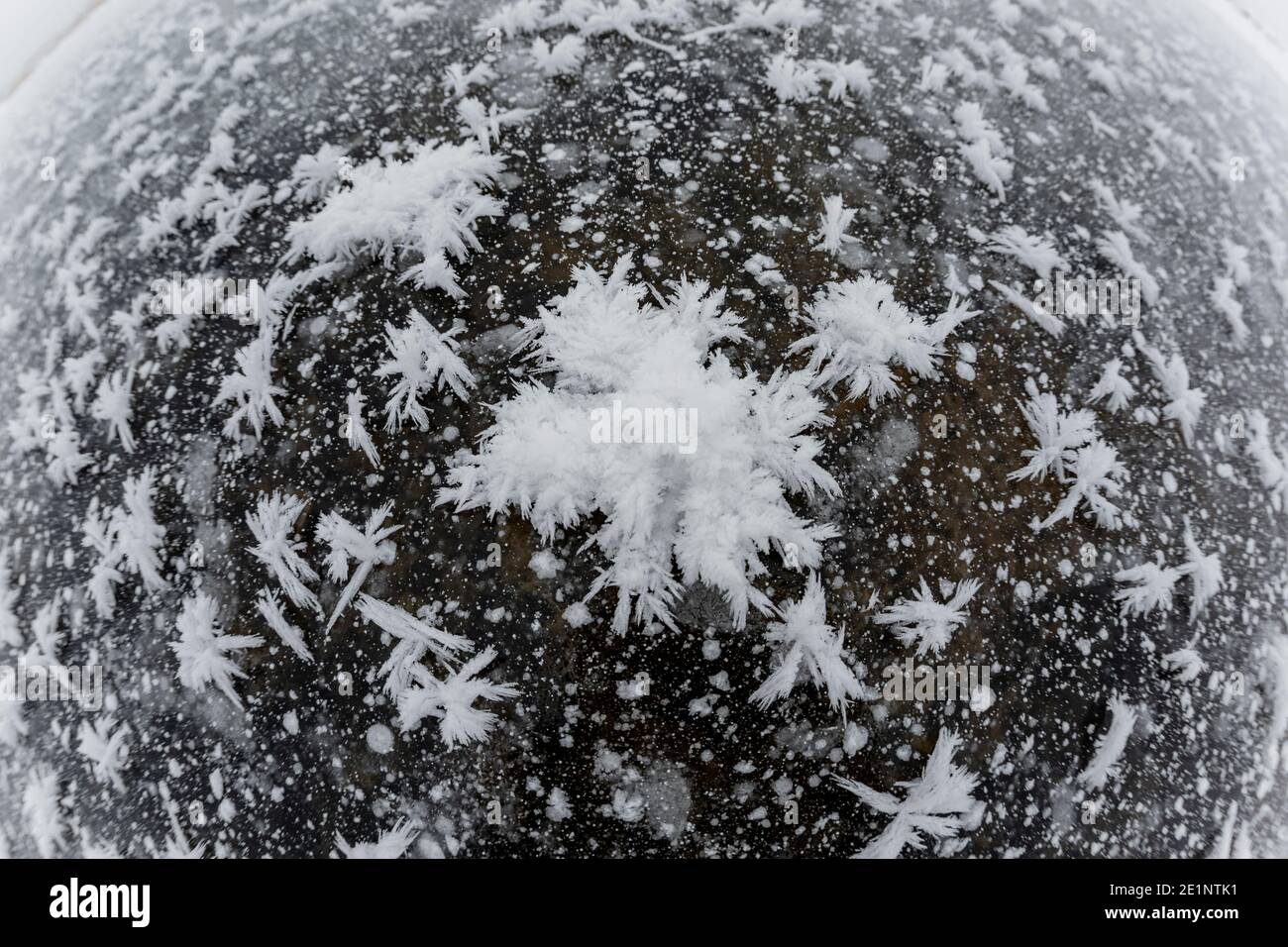 Makro Fisheye Schuss von Schneekristallen auf dem Eis Gefrorener See Stockfoto