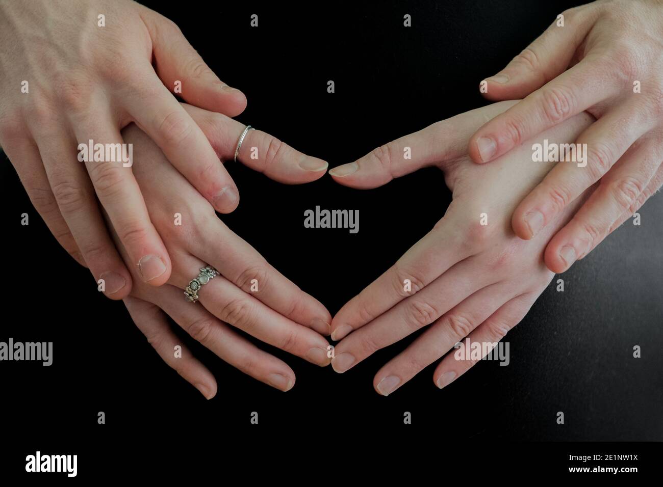 Schwangere Frauen mit Partner bilden Hand geformten Herzen auf der Beule. Stockfoto
