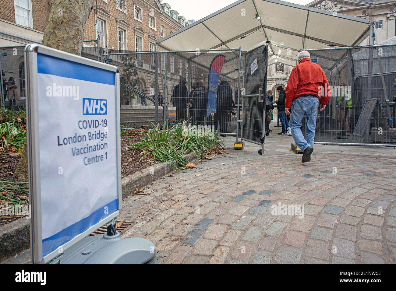 Die Leute stehen am NHS COVID-19 London Bridge Impfzentrum an 1 Stockfoto