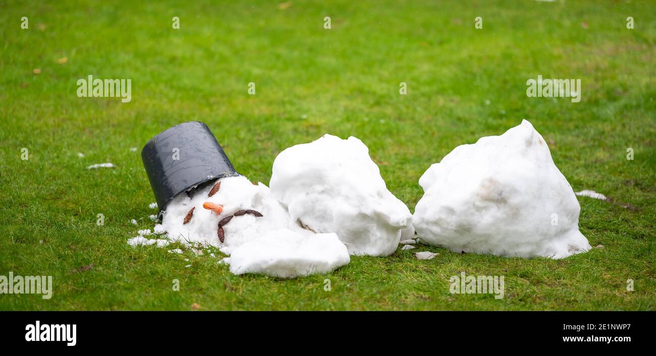Ein geschmolzener Schneemann mit einem traurigen Gesicht als Symbol für das Ende des Winters. Stockfoto