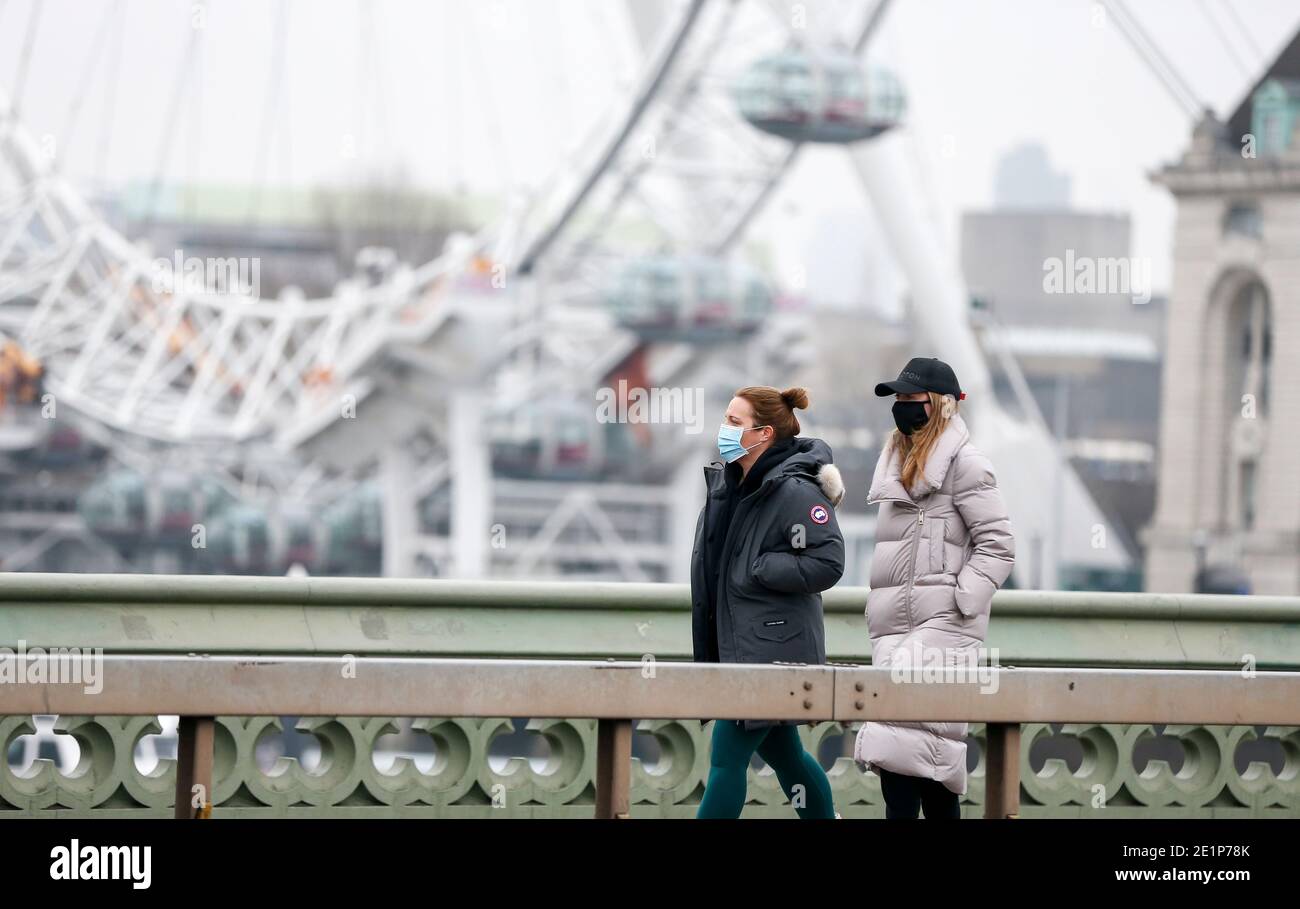 London, Großbritannien. Januar 2021. Menschen, die Gesichtsmasken tragen, gehen am "London Eye" in London, Großbritannien, 8. Januar 2021 vorbei. Großbritannien verzeichnete weitere 68,053 Coronavirus-Fälle, die höchste tägliche Zunahme seit Beginn der Pandemie im Land, offizielle Zahlen zeigten am Freitag.die Gesamtzahl der Coronavirus-Fälle im Land beträgt 2,957,472, die Daten zeigten. Auch am Freitag erklärte der Bürgermeister von London Sadiq Khan einen "großen Zwischenfall" in der britischen Hauptstadt, da steigende Coronavirus-Fälle die Krankenhäuser zu überwältigen drohen. Quelle: Han Yan/Xinhua/Alamy Live News Stockfoto