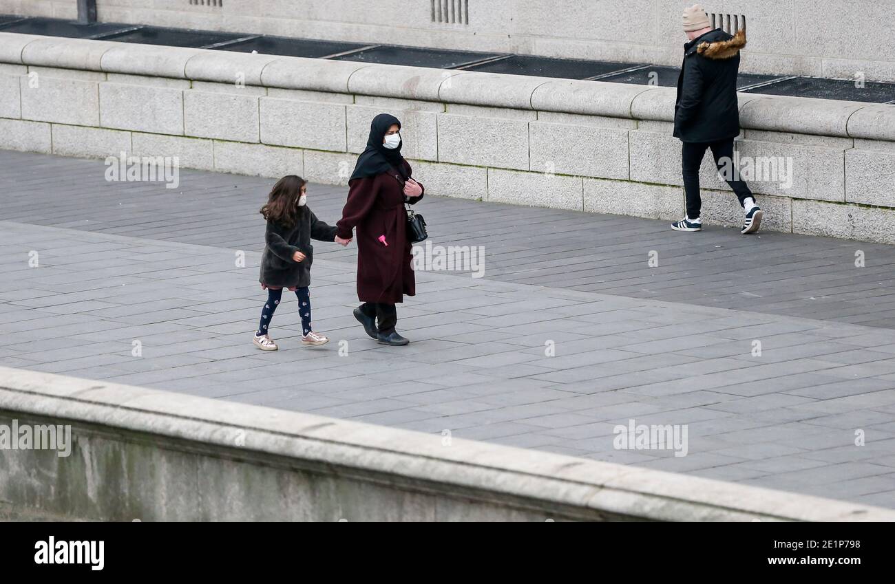 London, Großbritannien. Januar 2021. Menschen mit Gesichtsmasken spazieren an der Themse in London, Großbritannien, 8. Januar 2021. Großbritannien verzeichnete weitere 68,053 Coronavirus-Fälle, die höchste tägliche Zunahme seit Beginn der Pandemie im Land, offizielle Zahlen zeigten am Freitag.die Gesamtzahl der Coronavirus-Fälle im Land beträgt 2,957,472, die Daten zeigten. Auch am Freitag erklärte der Bürgermeister von London Sadiq Khan einen "großen Zwischenfall" in der britischen Hauptstadt, da steigende Coronavirus-Fälle die Krankenhäuser zu überwältigen drohen. Quelle: Han Yan/Xinhua/Alamy Live News Stockfoto