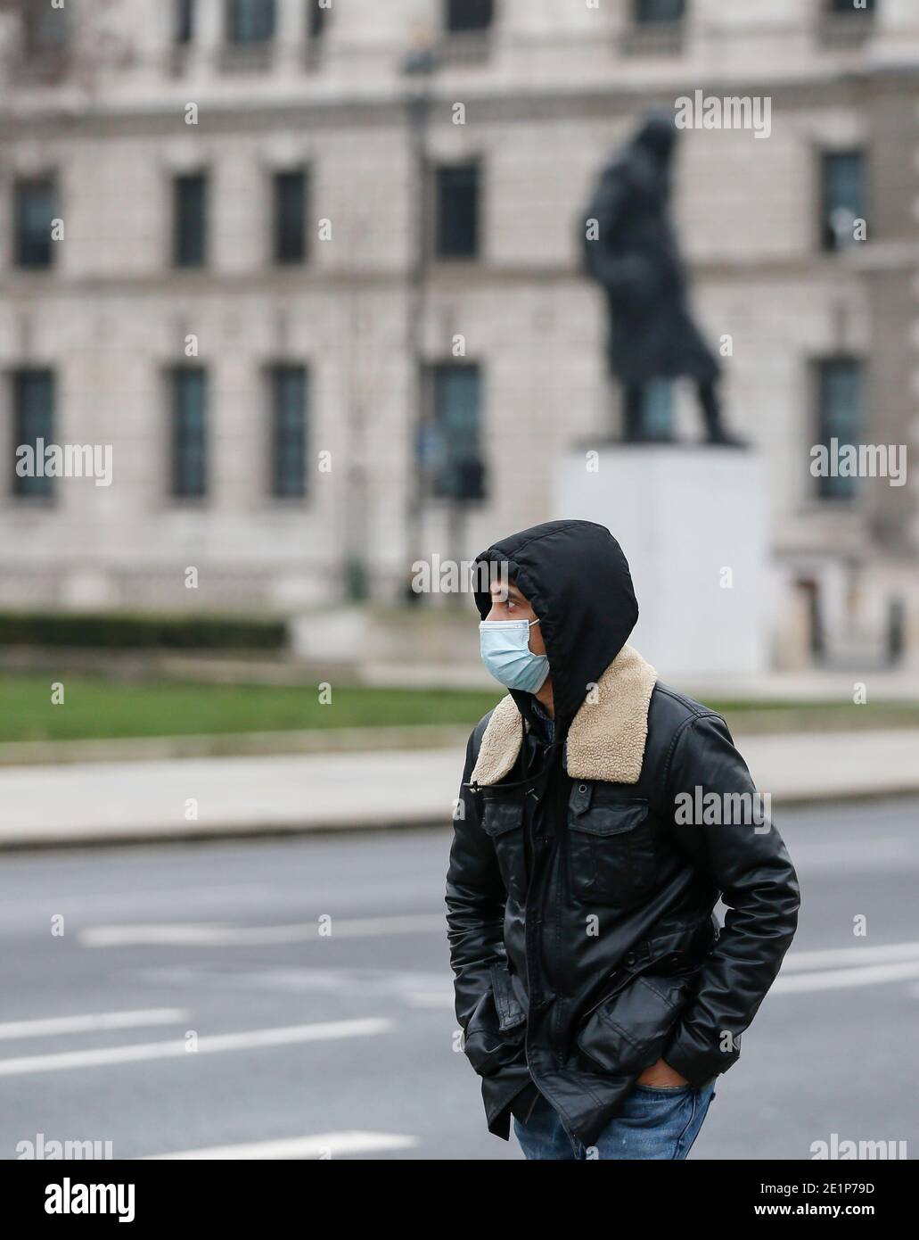 London, Großbritannien. Januar 2021. Ein Mann mit Gesichtsmaske geht an der Winston Churchill Statue am Parliament Square in London, Großbritannien, 8. Januar 2021 vorbei. Großbritannien verzeichnete weitere 68,053 Coronavirus-Fälle, die höchste tägliche Zunahme seit Beginn der Pandemie im Land, offizielle Zahlen zeigten am Freitag.die Gesamtzahl der Coronavirus-Fälle im Land beträgt 2,957,472, die Daten zeigten. Auch am Freitag erklärte der Bürgermeister von London Sadiq Khan einen "großen Zwischenfall" in der britischen Hauptstadt, da steigende Coronavirus-Fälle die Krankenhäuser zu überwältigen drohen. Quelle: Han Yan/Xinhua/Alamy Live News Stockfoto