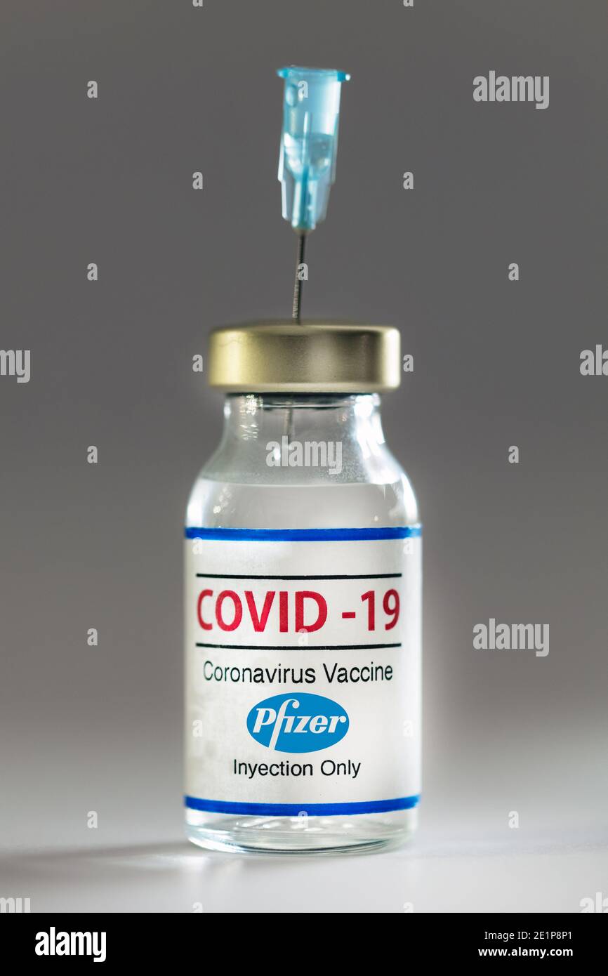 Flasche Coronavirus-Impfstoff mit dem Pfizer-Logo und einer Nadel im Inneren. Stockfoto